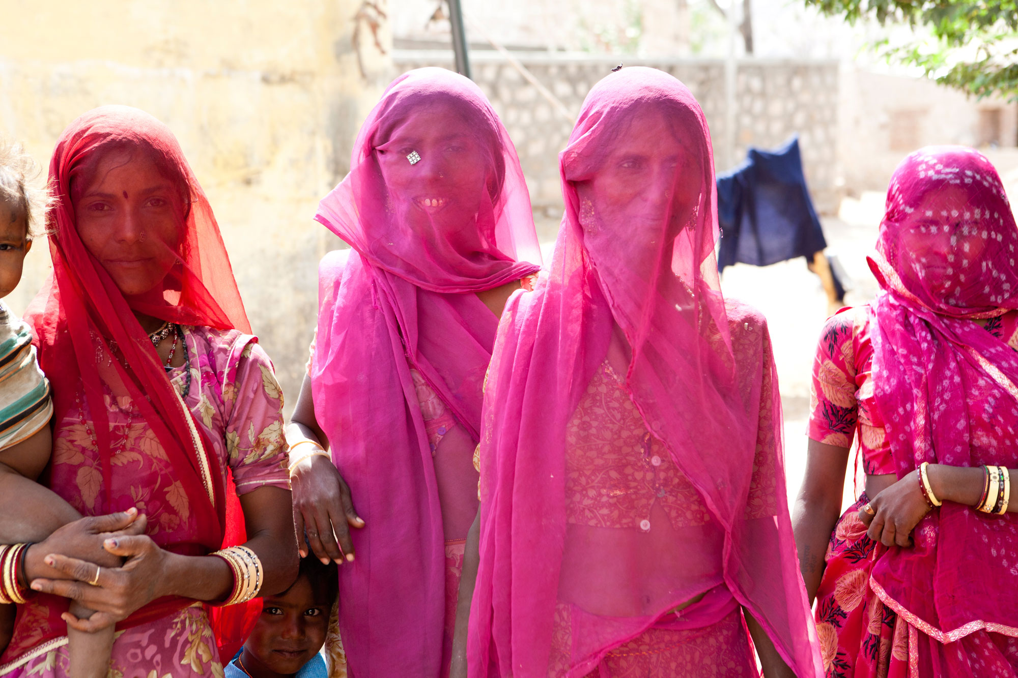 Girls in a village wearing pink sarees, standing in a line