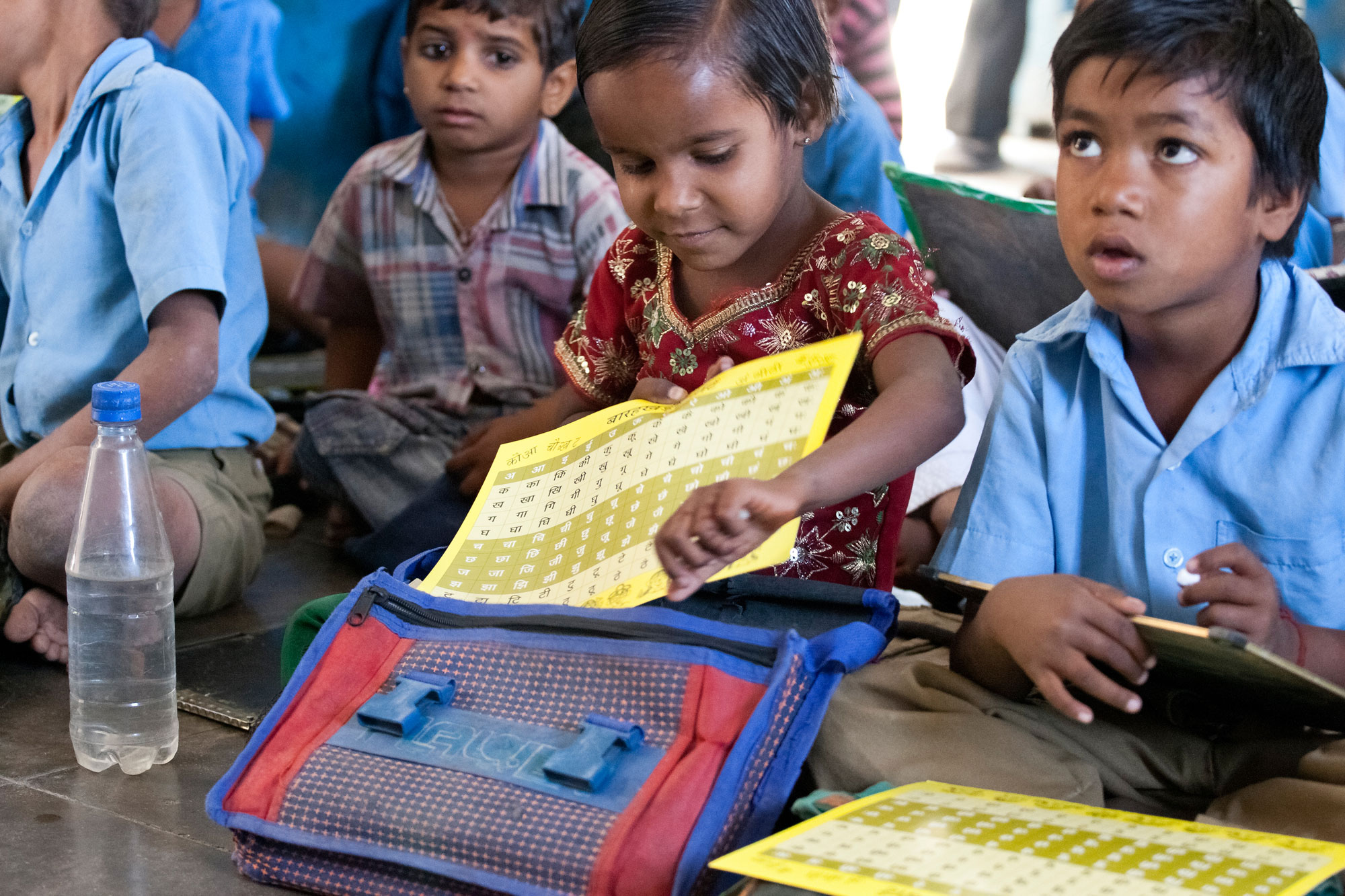 A young underprivileged girl keeping her Hindi sheets inside her bag