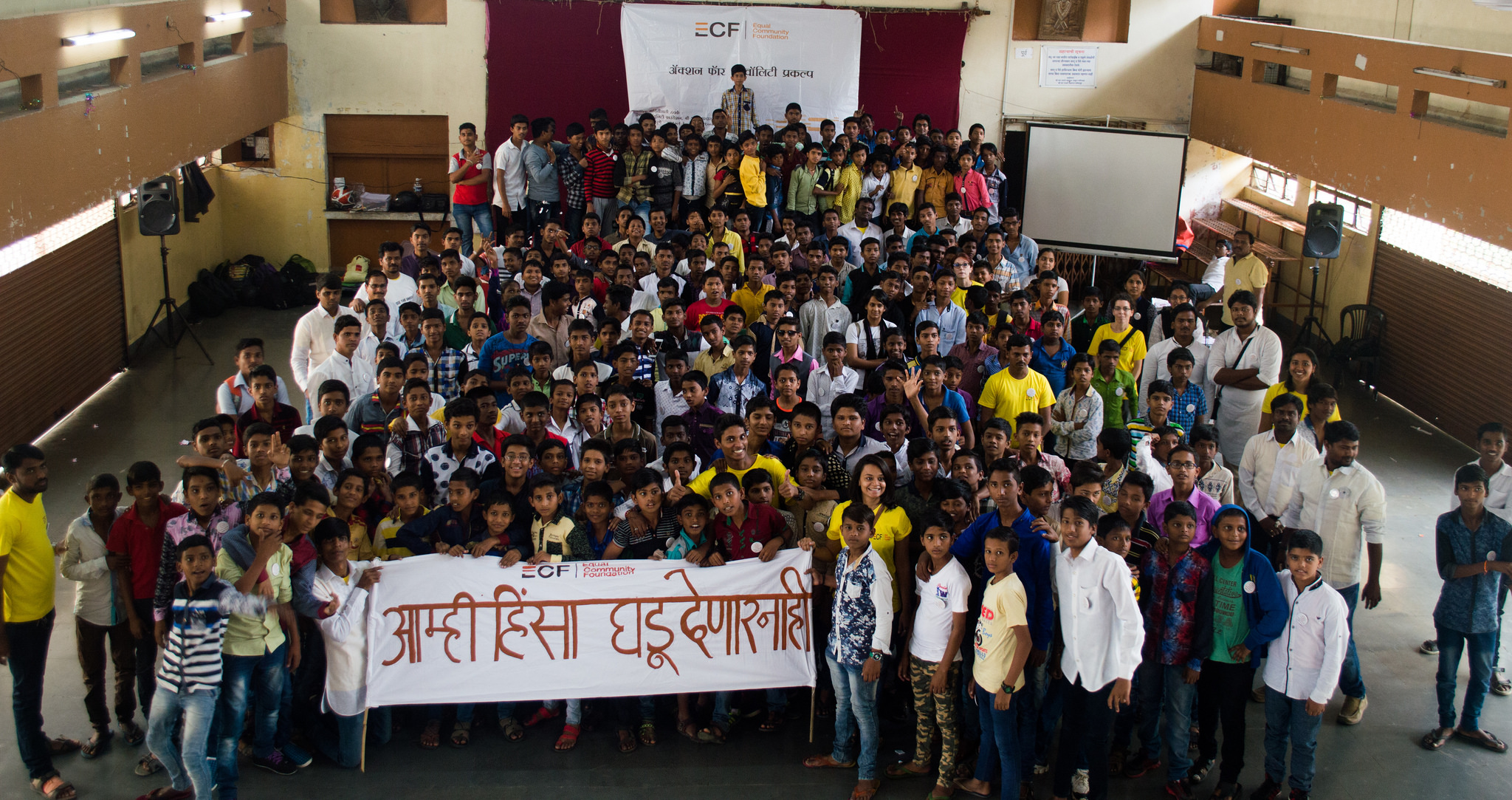 ECF young boys and men standing in a group with a banner - prevention of violence against women