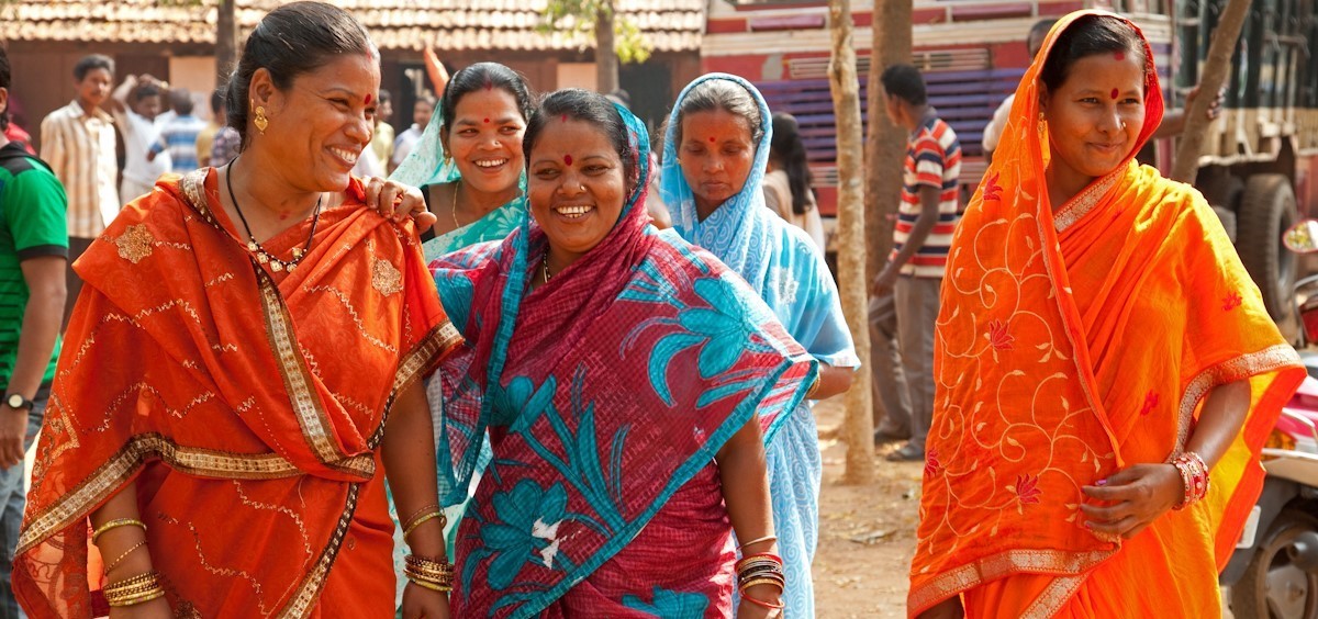 A few women in sarees laughing