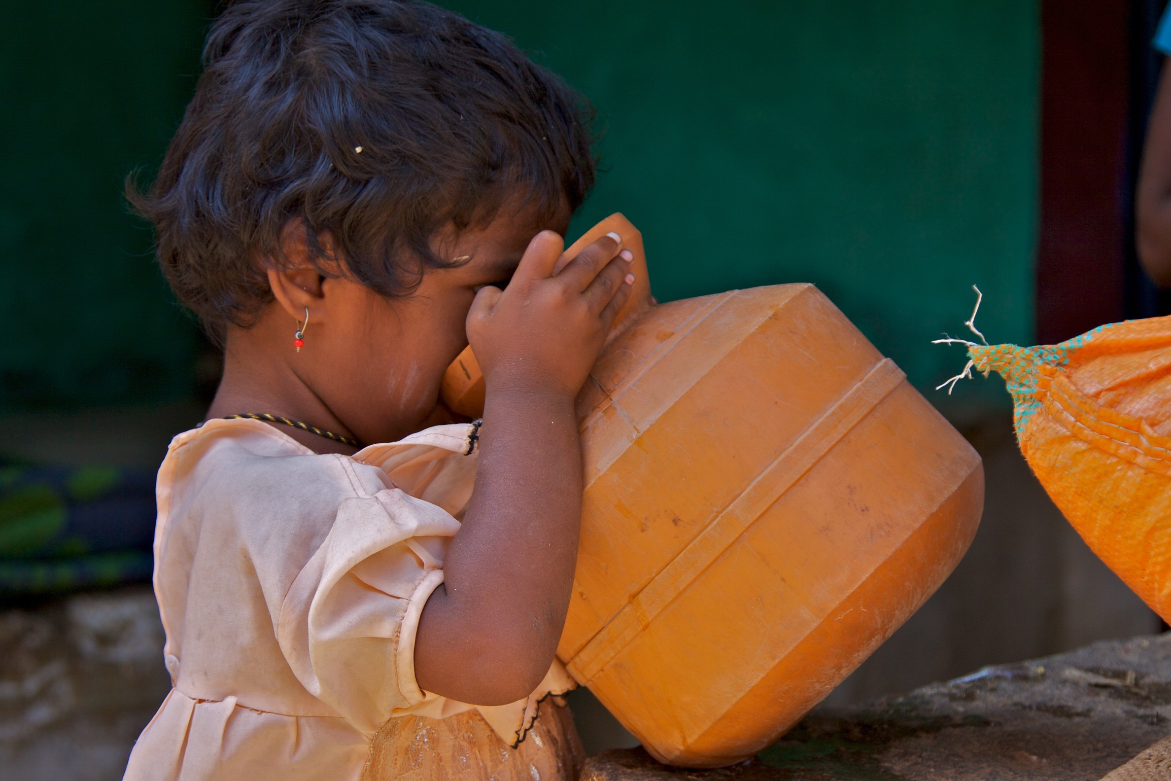 A girl drinking water from an earthen pot_ASwaminathan