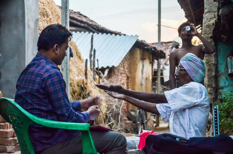 A man doing a health check in a tribal community_tribal health_SEARCH