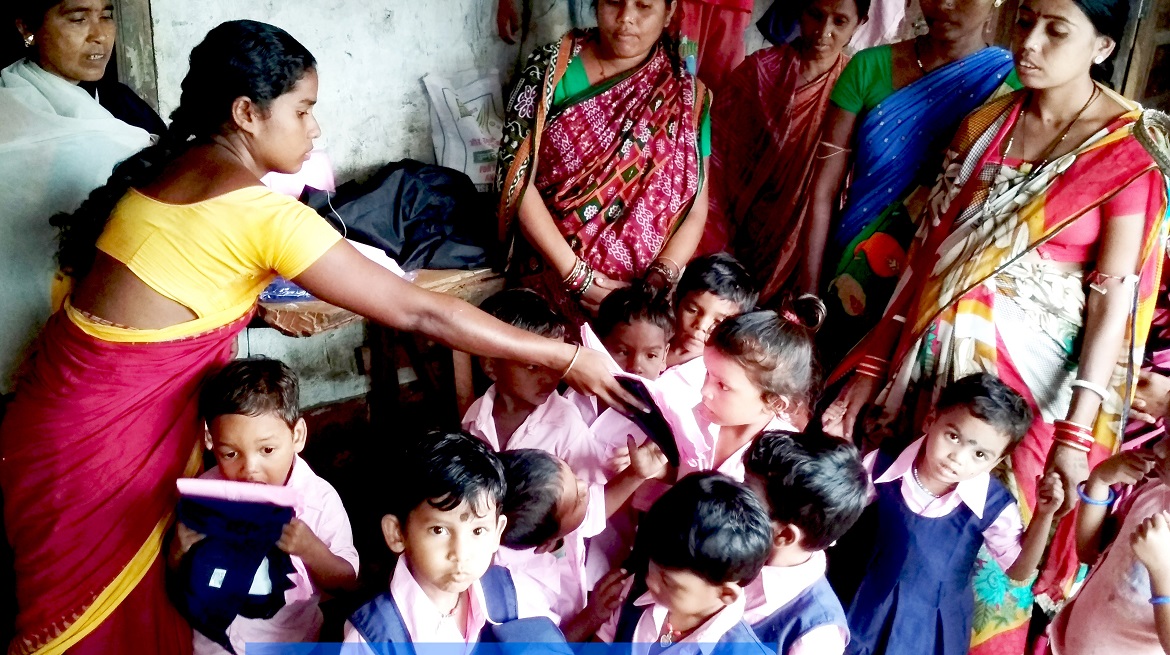 Women distributing uniforms to children