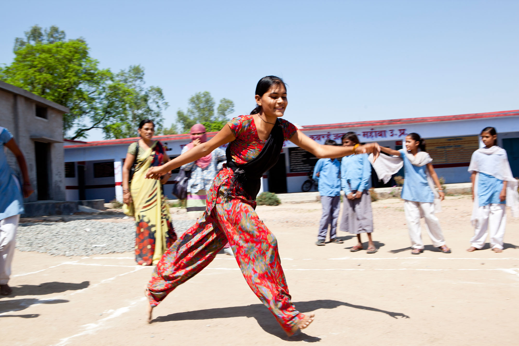 A young girl playing in a school field. Funders who invest in educating adolescent girls on delaying marriage and childbearing, should readjust how they measure the success of the programmes.