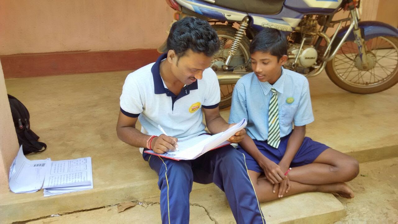 Volunteer teaching something to a village boy