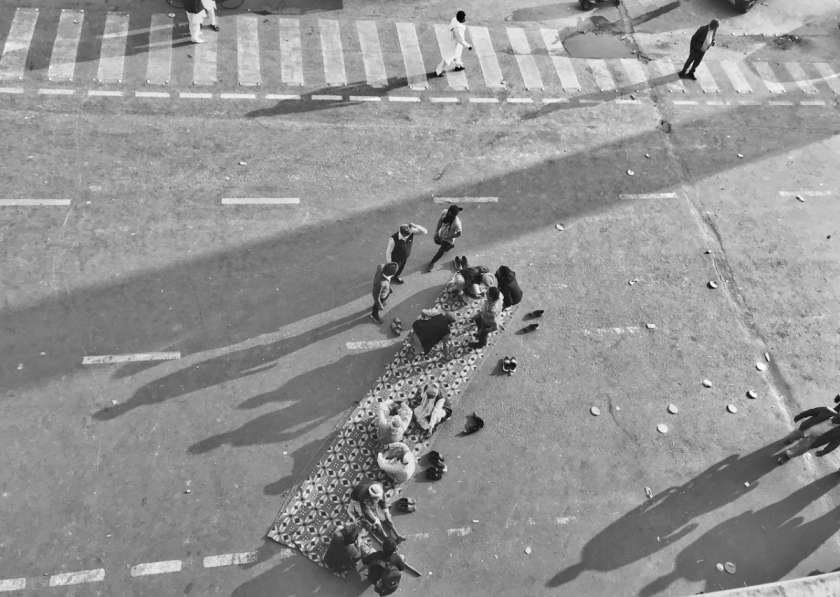 People sitting on a mat diagonally on the road_farmers protest