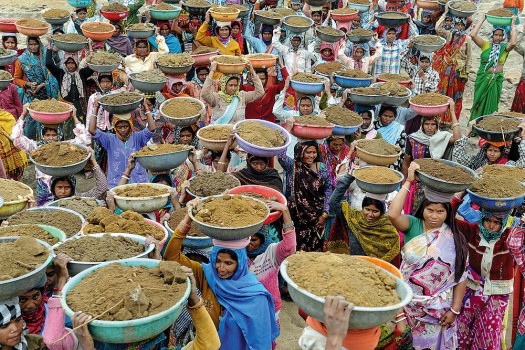 NREGA workers holding soil in containers on their heads-photo courtesy Tribhuvan Tiwari, Outlook India