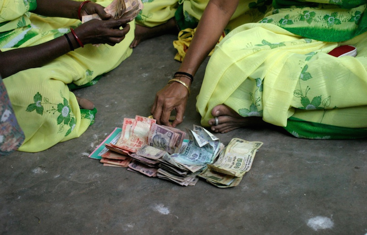 Women sitting with Indian money-Microfinance