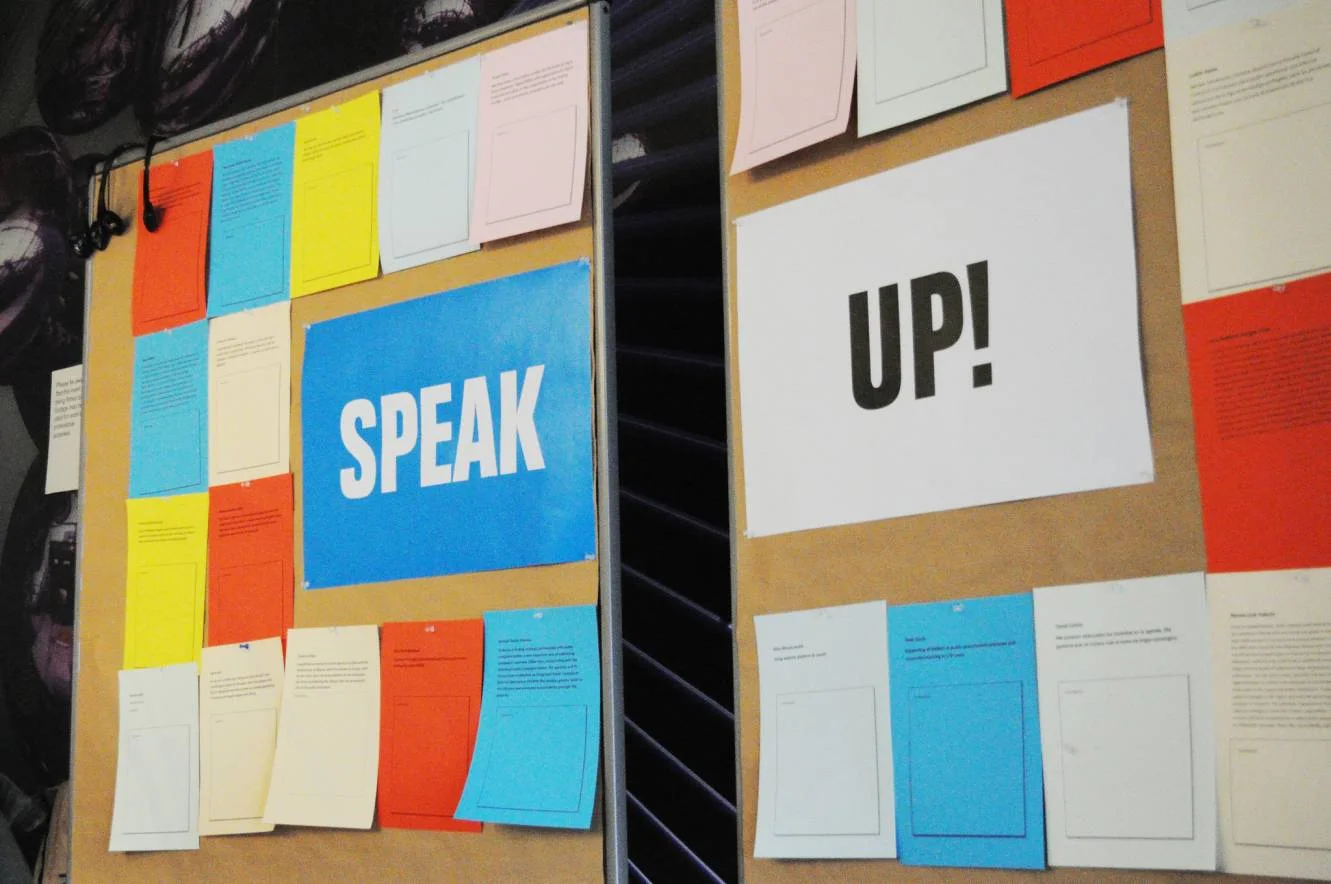 a board with speak up written on it-speak up