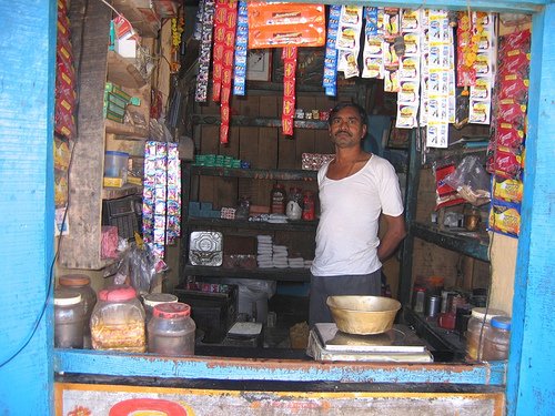 Man wearing white t-shirt in a kirana store