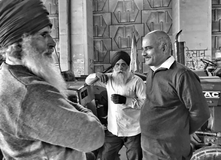 Three men standing talking-farmers protest