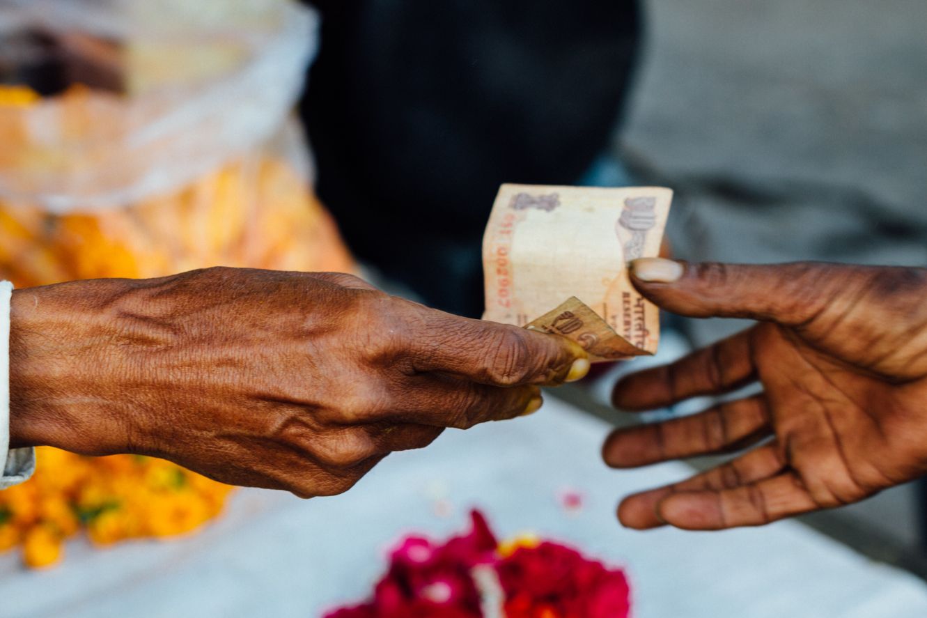 hands exchaging a 10 rupee note_social finance_flickr