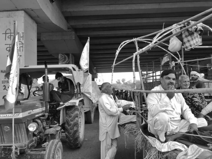 People sitting inside a tractor and another vehicle-farmers protest