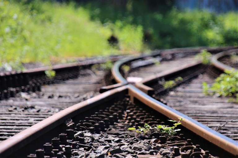 two railway lines intersecting with grass at the side-corruption