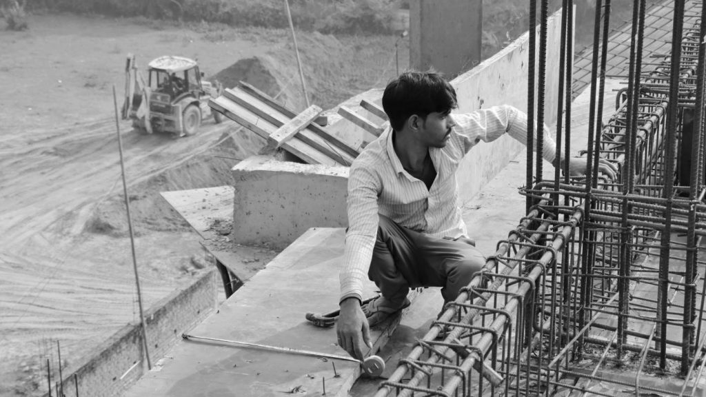 Migrant construction workers casting the roof of the building under construction on site