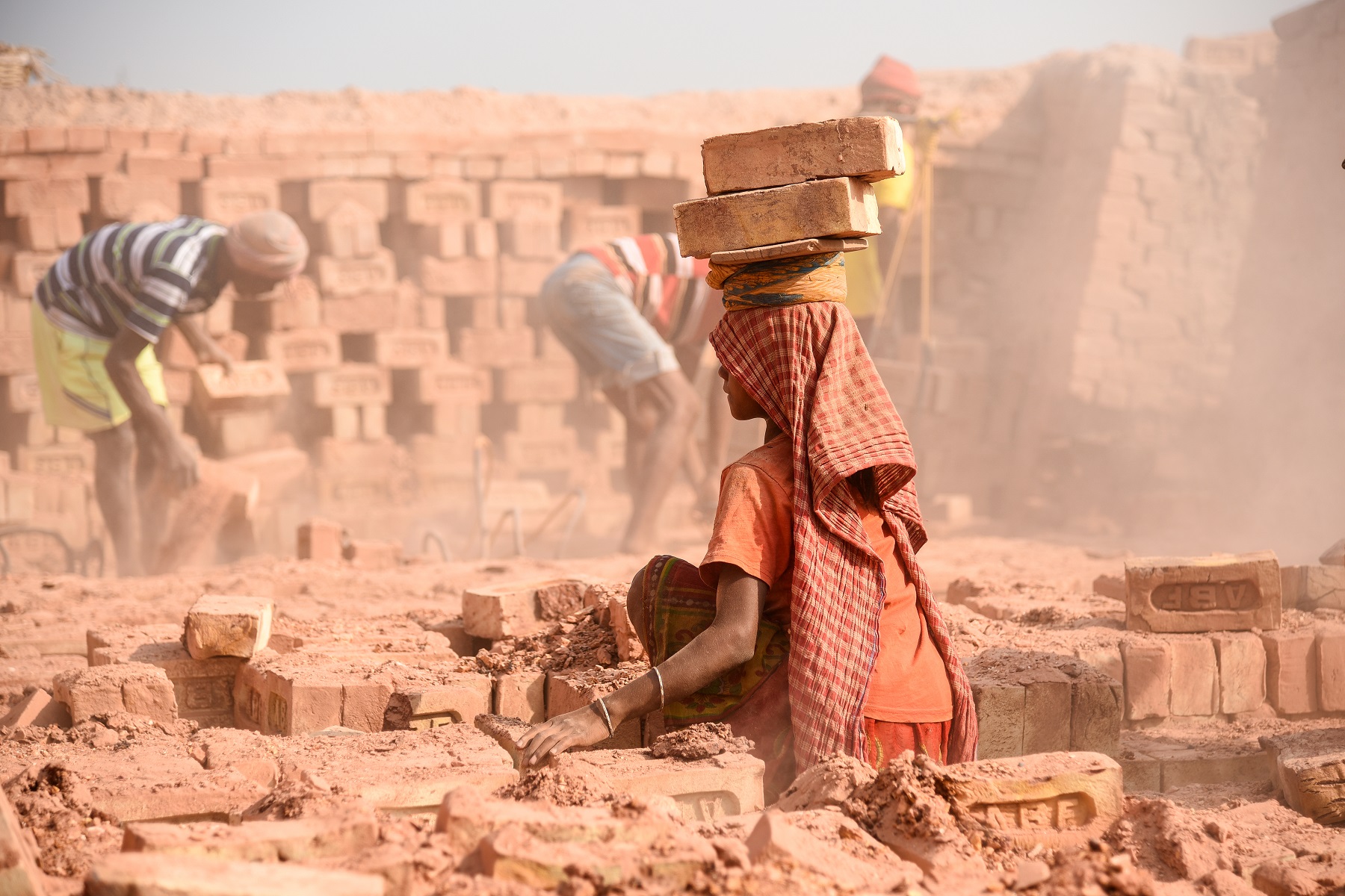 An Indian woman labourer with bricks on her head at the brick kiln