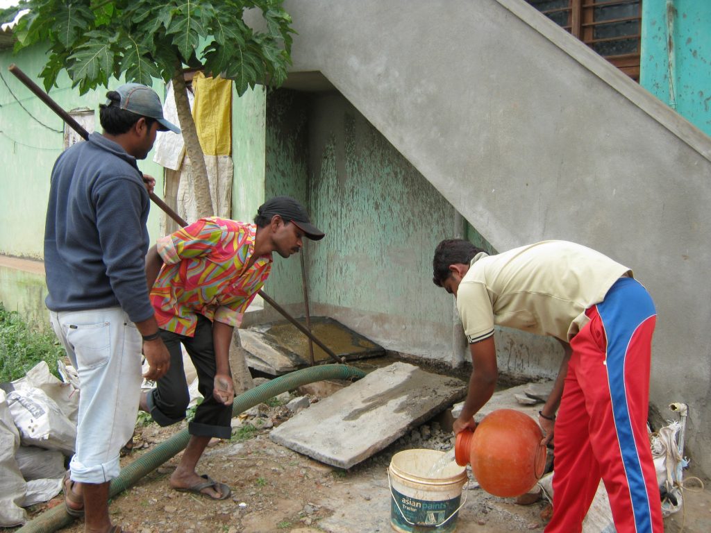 Men pumping a sewage pit_sanitation workers_epw