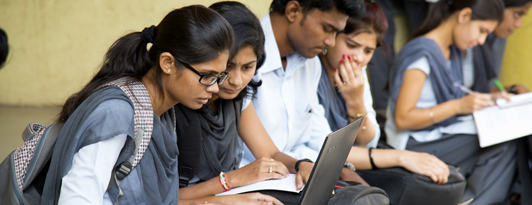 Indian students looking at a laptop