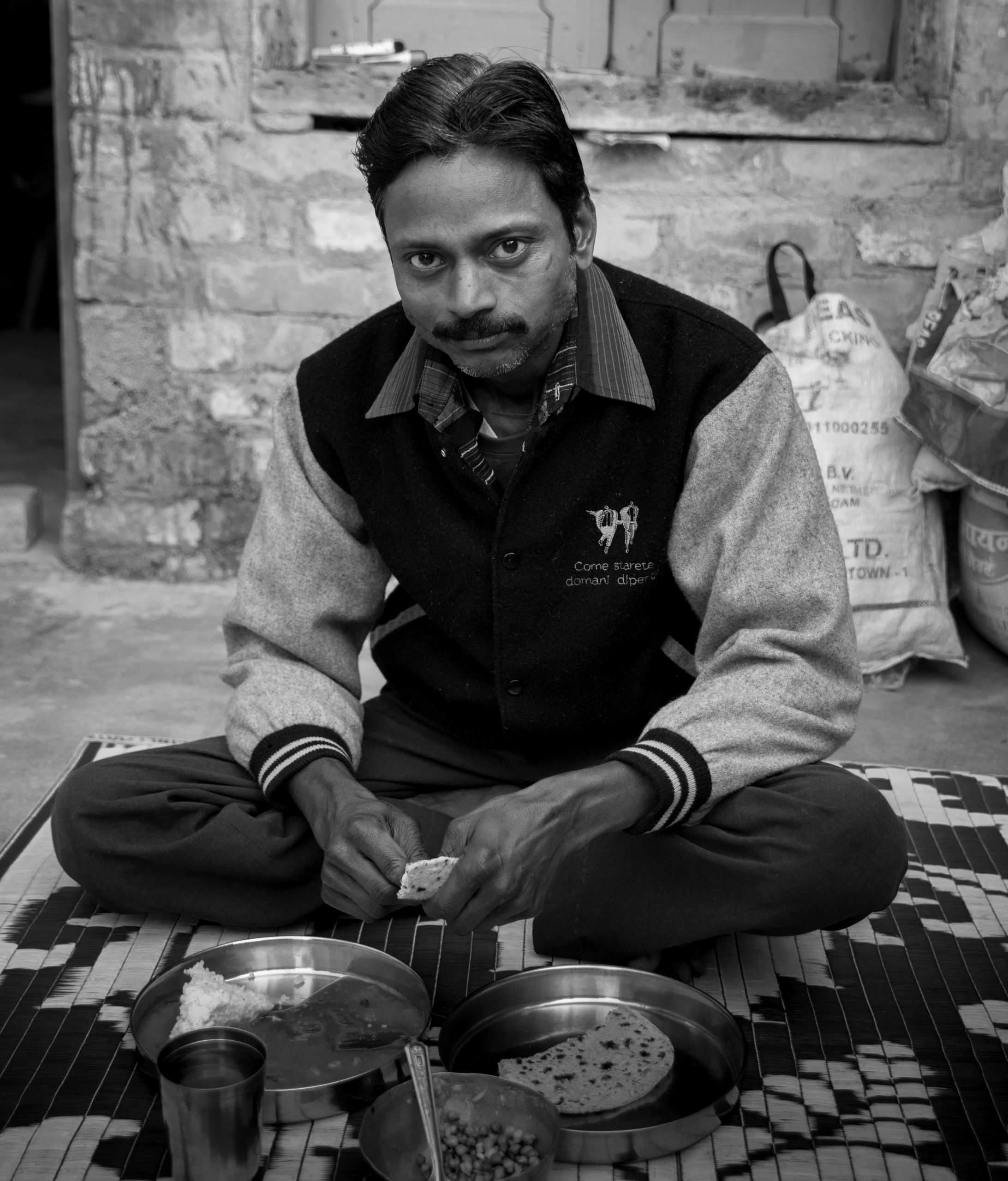 man sitting and eating on the ground