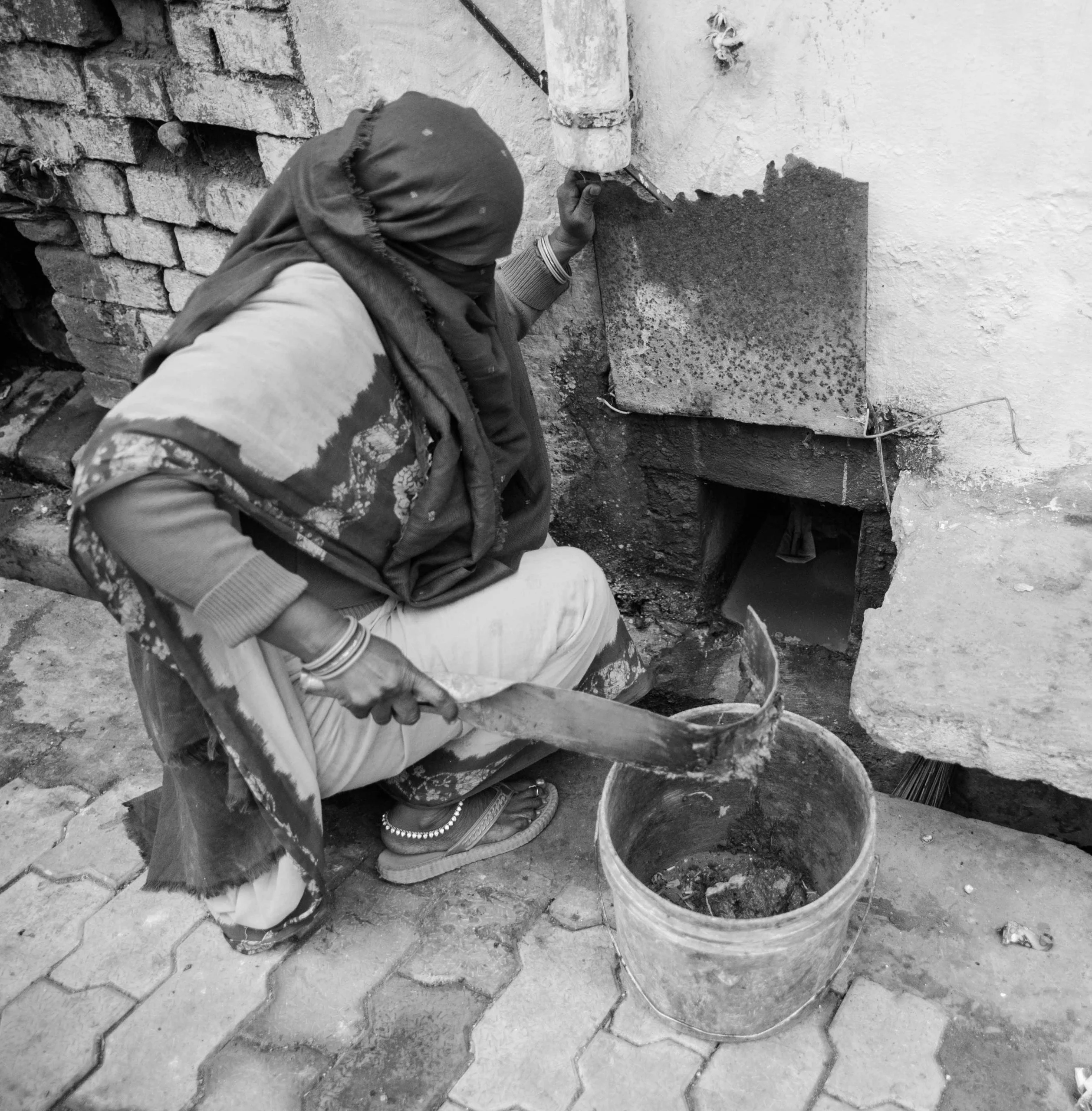 woman manually cleaning latrine