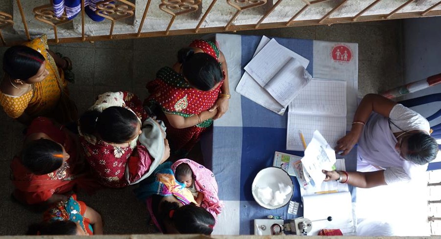 Indian women with their babies waiting for immunisation