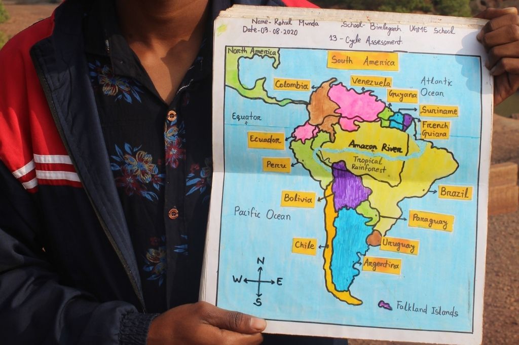 close up of Rahul Munda holding up a handrawn map of latin america-education. As learning went digital due to COVID-19, a group of teachers working in India’s villages took internet to people’s homes, making education more inclusive.