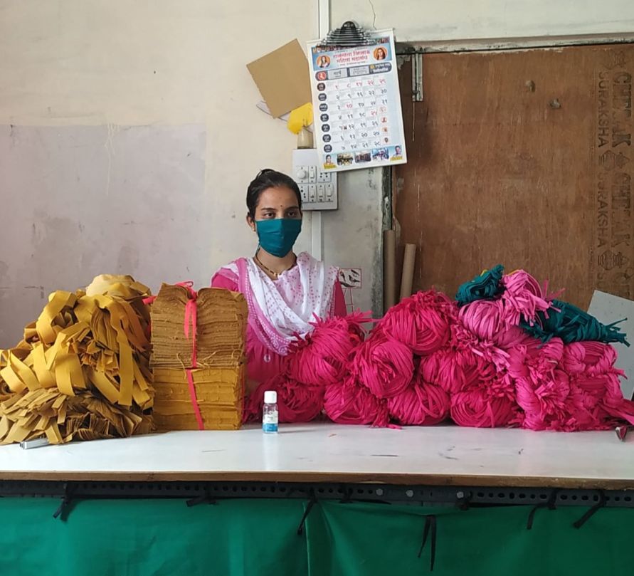 Roopali standing behind a pile of masks with a mask on-women entrepreneur