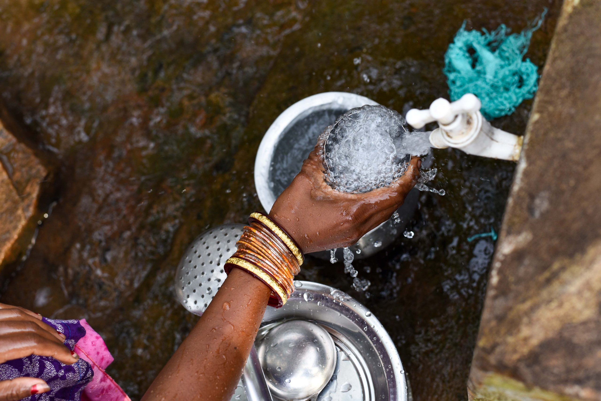 a woman collects drinking water in odisha_rural sanitation_gram vikas