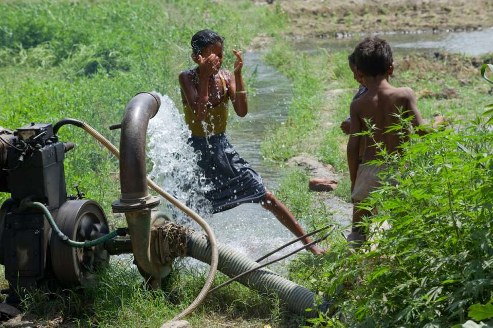 children playing at a borewell in indian farm_farmers