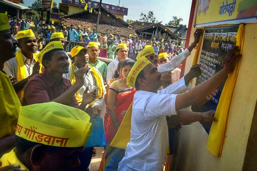 Adivasi lawyer and social activist Lalsu Nogoti inaugurating a board in front of a crow-adivasi rights