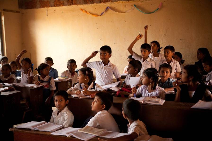 Classroom with school uniform wearing children-development impact bonds