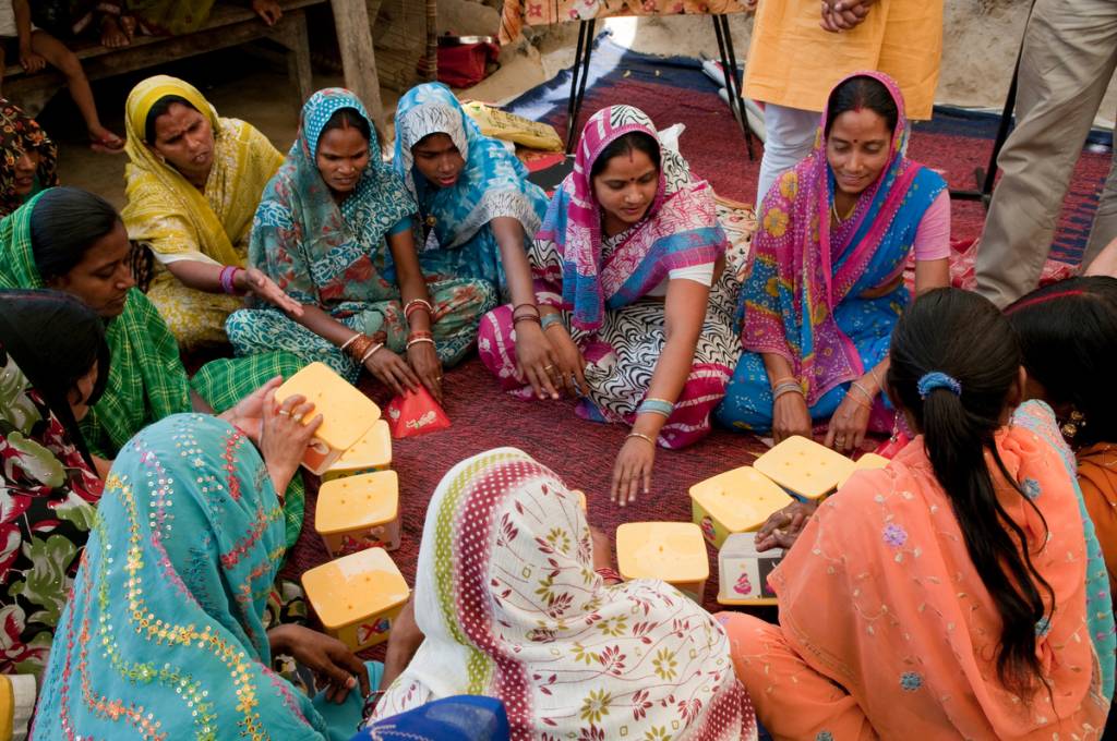 women sitting in a circle participating in a game that promotes family wellness-human rights projects