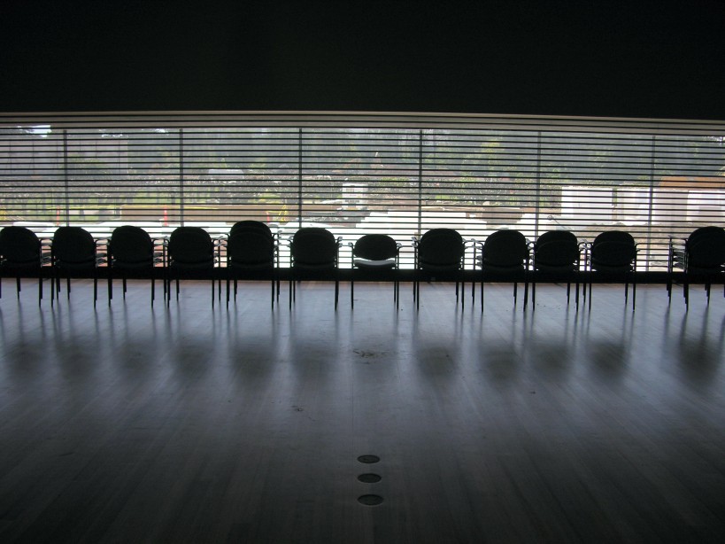 A row of empty chairs lined up in an empty room_board members