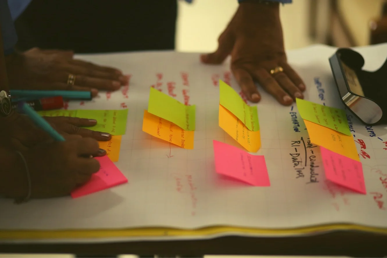 two pairs of hands resting on a chart with post-it notes - government