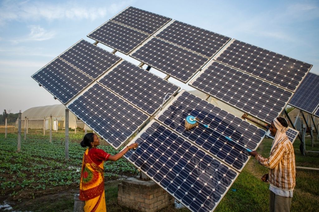 Farm workers clean the solar panels for better efficiency-renewable energy