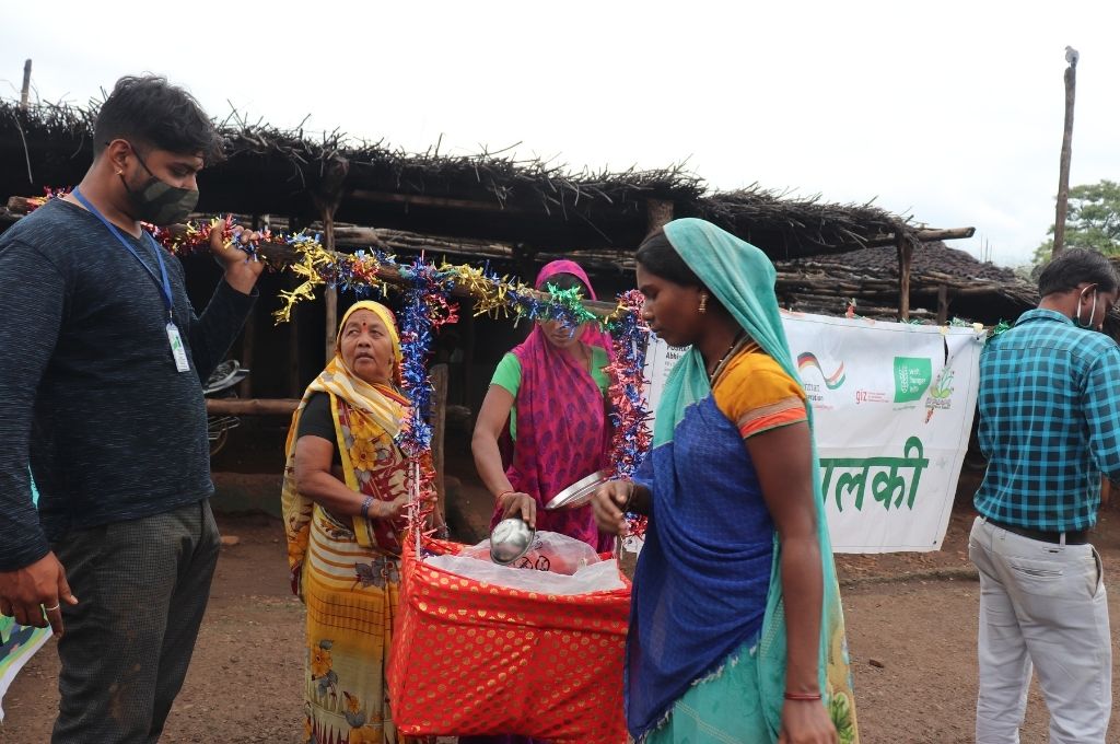 women from the korku community with a palanquin that contains food grains-korku people