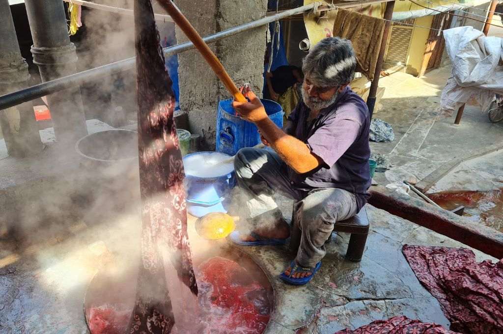 Batik artisan removing wax from cloth_batik Kachchh