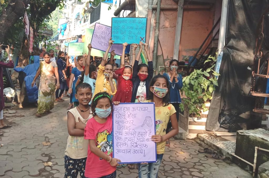 Young girls walking in the street holding posters protesting against domestic violence-adoloscents