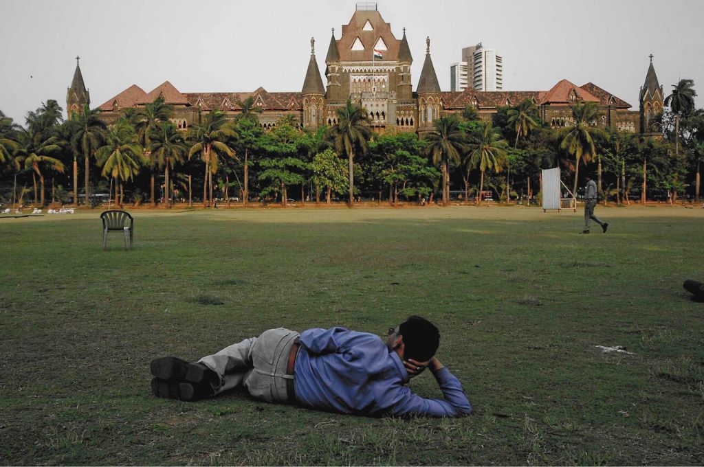 A man lying on the ground with his back to the camera, looking at the sky-Indian cities