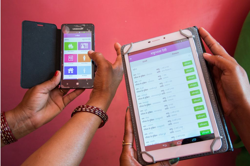 Women holding two digital devices for surveys