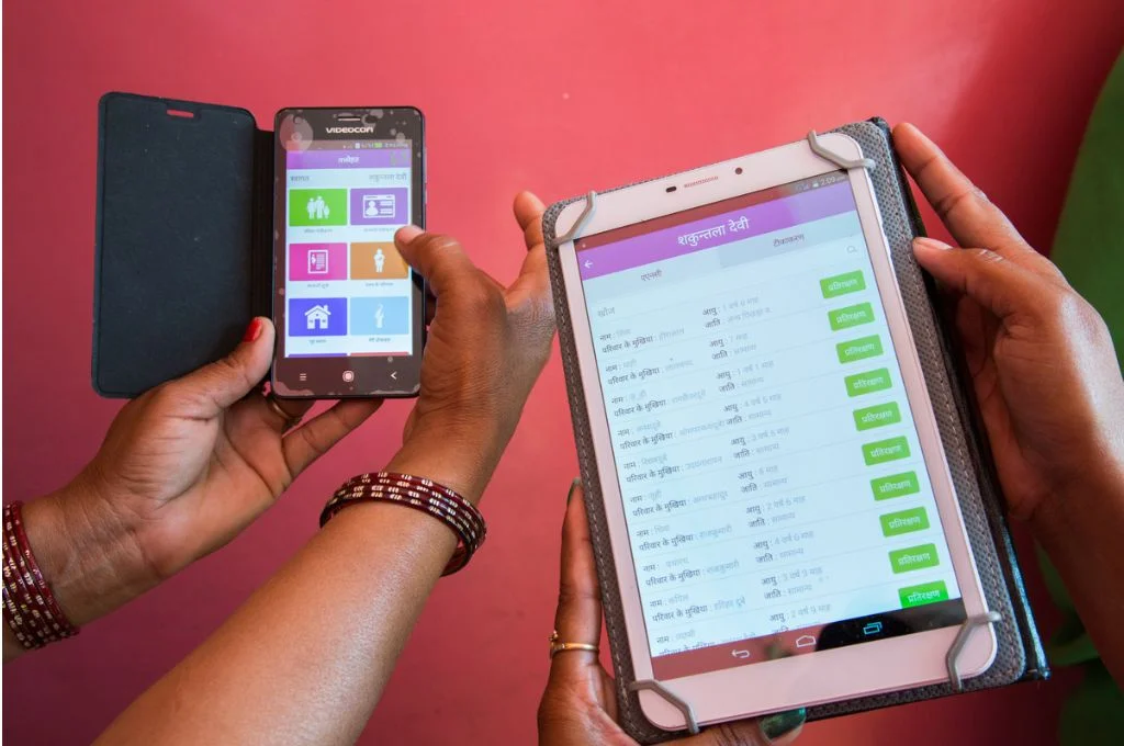 Women holding two digital devices for surveys