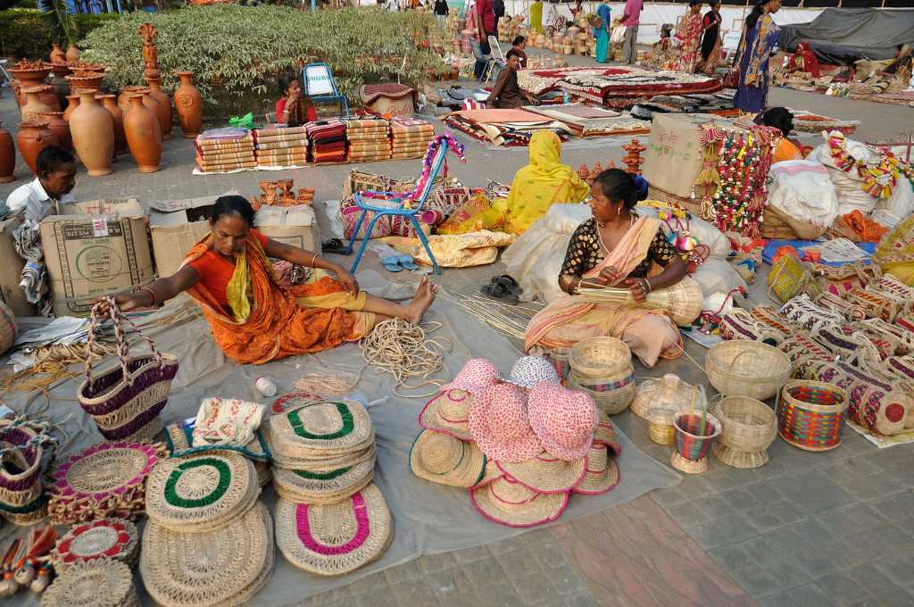 Two women sitting on the ground, surrounded by weaving baskets_open network for digital commerce