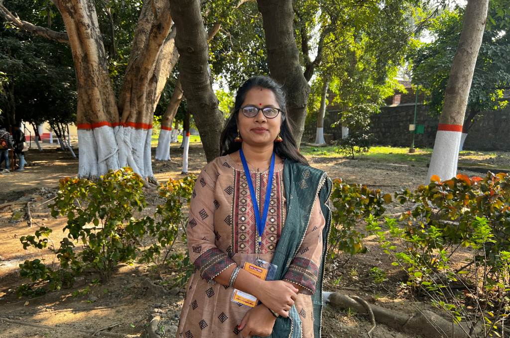 a woman with long hair and glasses standing in a garden--tribal women