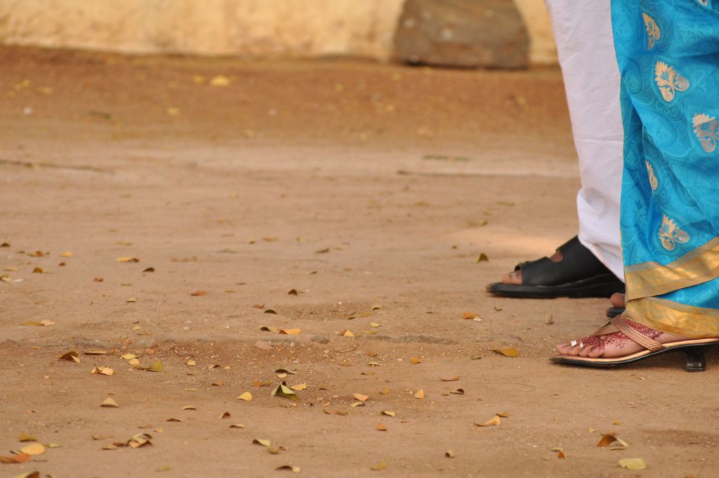 man in black sandles and woman in blue saree-child marriage