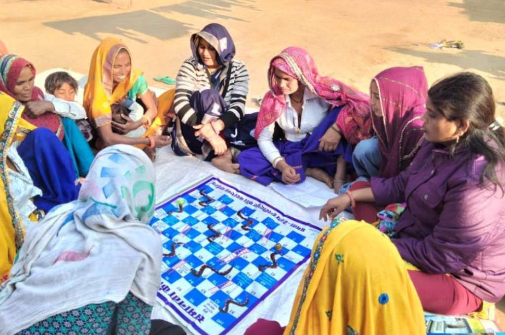 a group of women playing snakes and ladders--newly married women