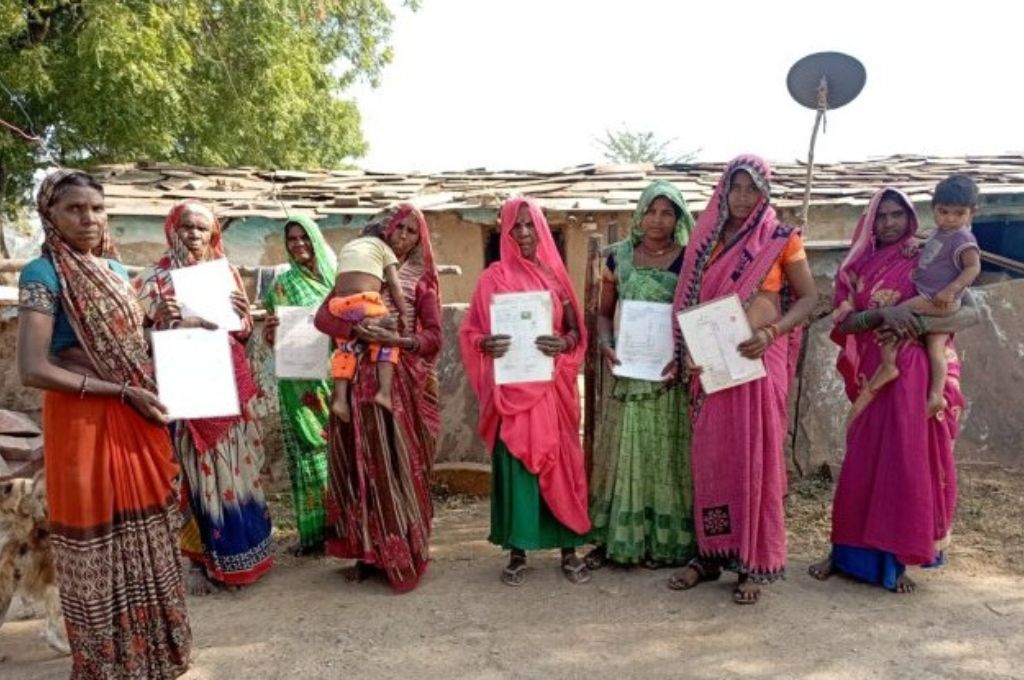 Adivasi people showing IFR papers--land rights