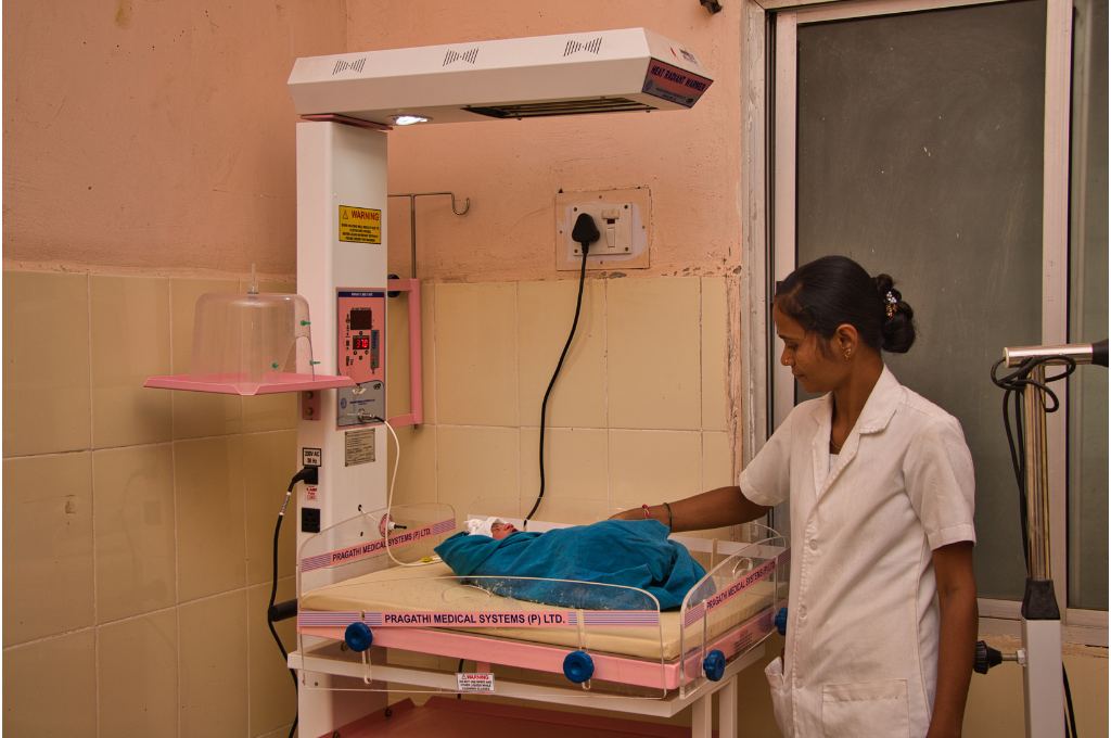 A health practitioner tends to a child in DRE powered baby warmer-solar