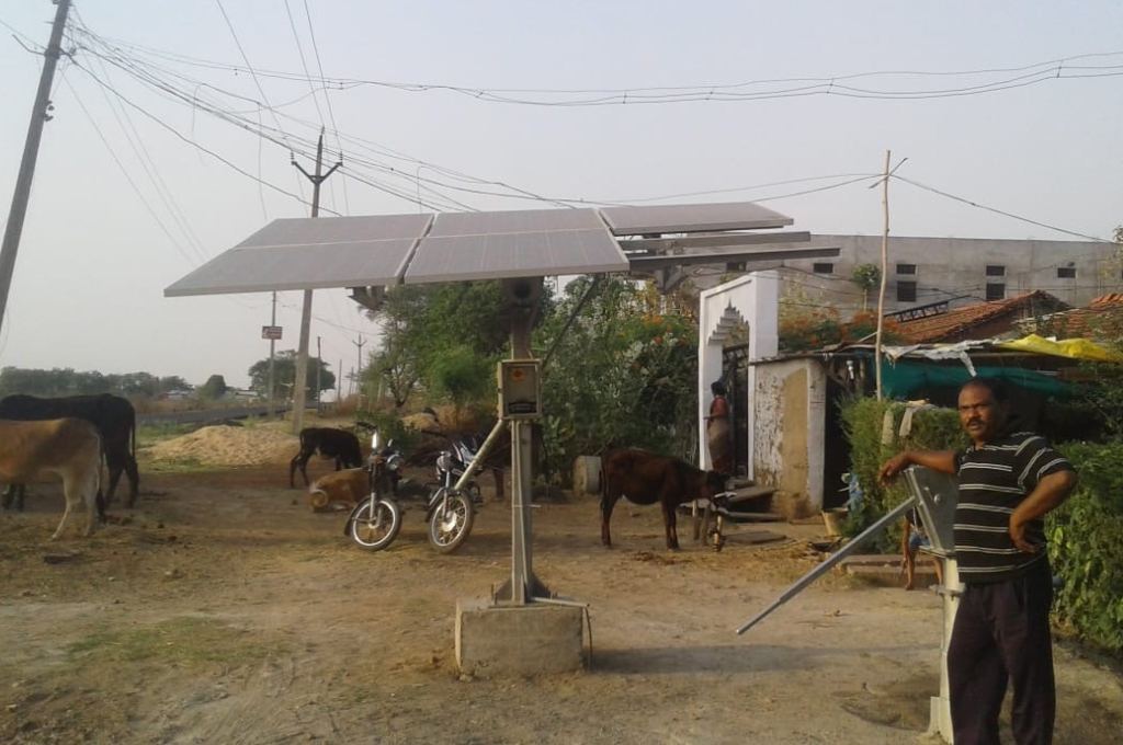 farmer standing next to solar panels on his farm-government