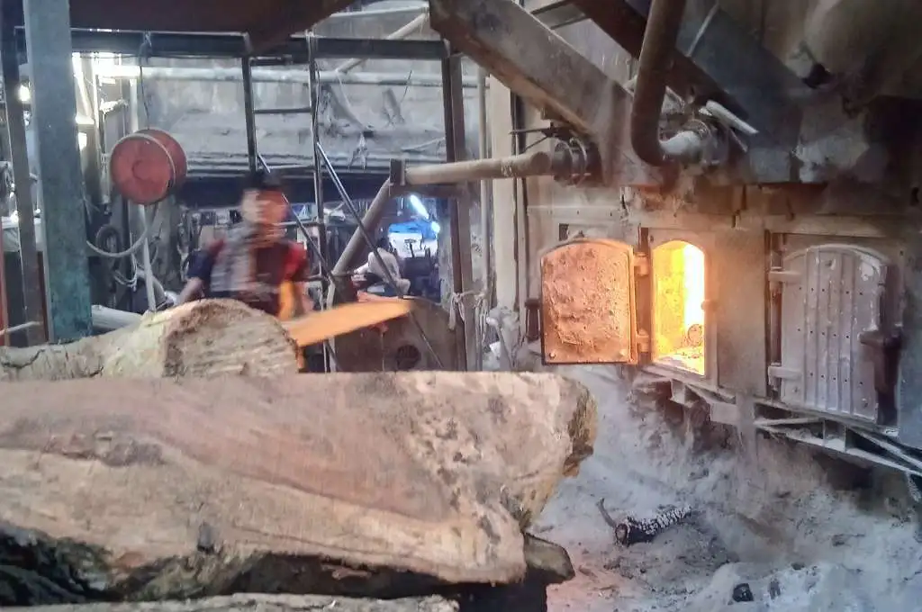 A worker working with a machine running on wood_boiler worker