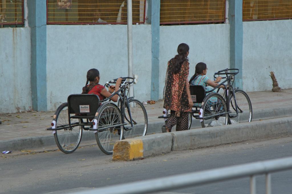 two young women with physical disability in a three-wheel bicycle-disability